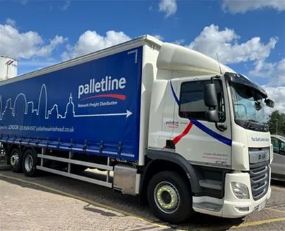 A Palletline Whitehead lorry parked outdoors on a sunny day, featuring a blue trailer with the London skyline graphic and the tagline “Network Freight Distribution”.