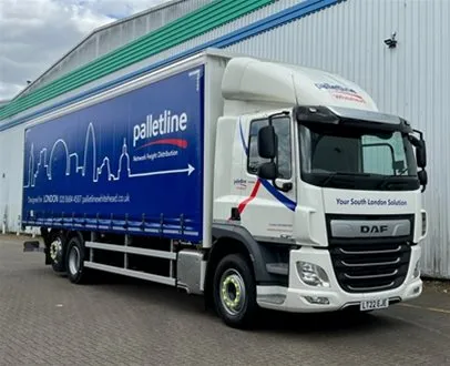 A Palletline Whitehead delivery truck parked outside a warehouse, featuring the company’s blue branding with a London skyline graphic on the trailer side.